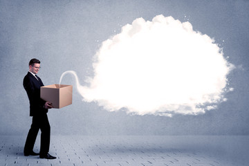 A young cheerful business person holding a cardboard box with illustration of white empty cloud concept.