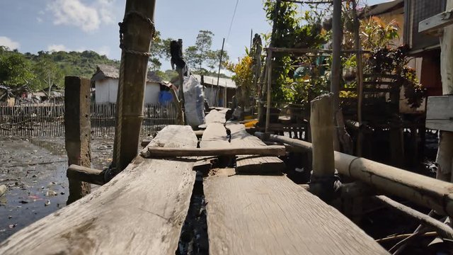 Houses in the Filipino slums for poor people. Wooden bridges from planks on high water. Poverty of people and families.