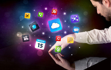 Male hands touching interactive table with colorful application icons on it 