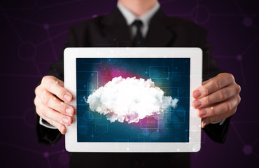 Businessman holding tablet with cloud icon and purple background