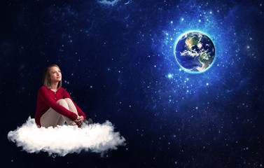 Fototapeta na wymiar Caucasian woman sitting on a white fluffy cloud sitting and wondering at planet earth
