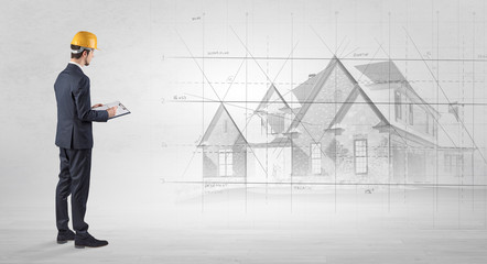 Architect standing and watching an imagined house plan
