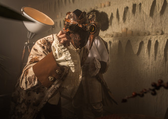 Actors in Steam punk masks and antique costumes indoor.