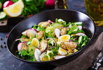 Dietary salad with mussels, quail eggs, cucumbers, radish and lettuce. Healthy food. Seafood salad.