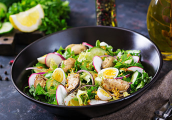 Dietary salad with mussels, quail eggs, cucumbers, radish and lettuce. Healthy food. Seafood salad.