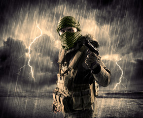 Portrait of a dangerous armed terrorist with mask and gun in a thunderstorm with lightning