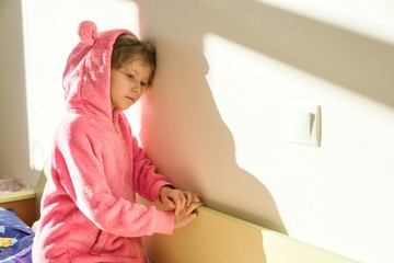 Fototapeta na wymiar Portrait of a girl in soft warm pink pajamas.
