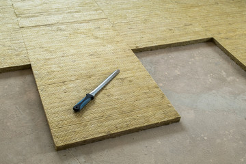 Thermal and sound protection in the interior of the apartment. Mounting knife and insulating mats made of stone wool on the floor of the apartment.
