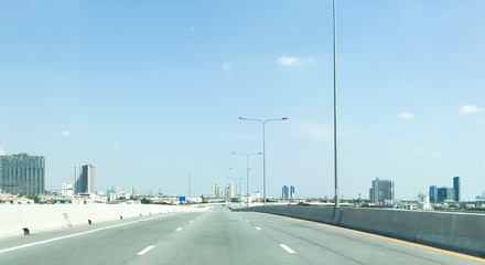 Empty super highway and architecture building in perspective on sunny day with beautiful blue sky and clouds.