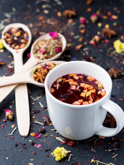 Fruit and herbal tea in white cup on dark concrete baclground.