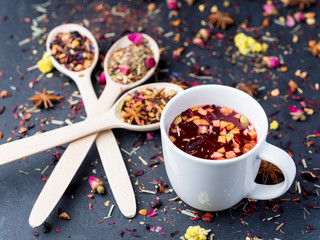 Fruit and herbal tea in white cup on dark concrete baclground.