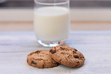 Chocolate chips cookies/ American cookies/ and healthy glass of milk at light wooden background/ Healthy morning
