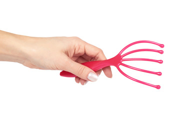 Plastic pink massager for head with hand, isolated on white background