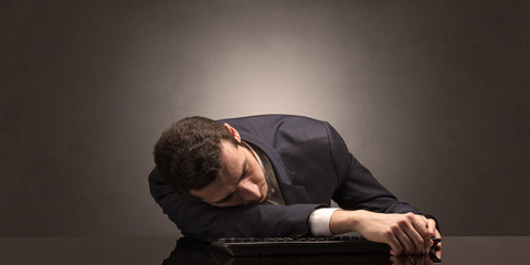 Obraz premium Young businessman fell asleep at his workplace with copy space