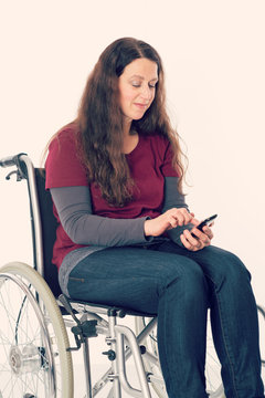young woman in wheelchair with smartphone