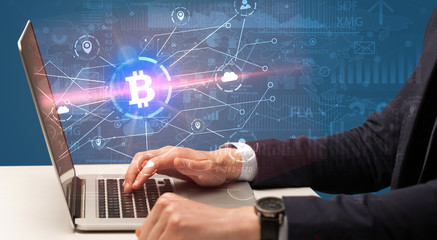 Hand checking on laptop global bitcoin exchange rate concept

