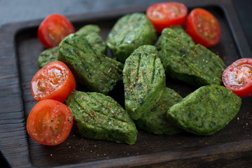 Close-up of pan fried vegetable nuggets with spinach, selective focus, shallow depth of field, horizontal shot