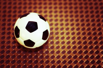 A toy soccer ball on an artificial background. Concept of the game of football.