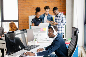 young African programmer working on personal computer in the call center
