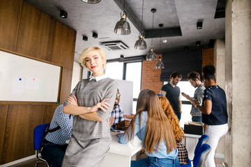 smiling pretty model leaning on the office desk and resting