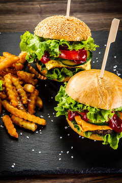  Tasty cheeseburgers with french fries served on fashionable black desk