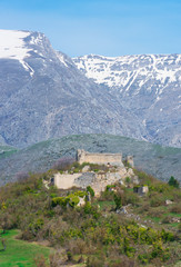 Alba Fucens (Italy) - An evocative Roman archaeological site with amphitheater and ruins of medieval castle, in a public park in front of Monte Velino mountain with snow, Abruzzo region, central Italy