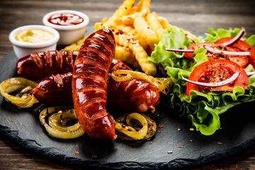 Photo sur Plexiglas Grill / Barbecue Grilled sausages, French fries and vegetables