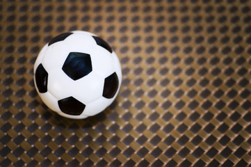 Fototapeta na wymiar A toy soccer ball on an artificial background. Concept of the game of football.