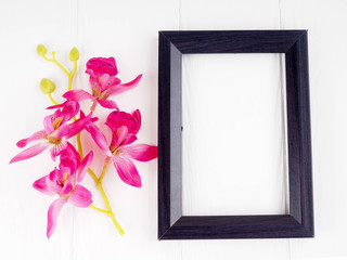 black wooden frame on white background with flowers, copy space for greetings