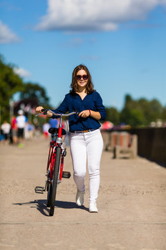 Urban biking - young woman and bike in city
