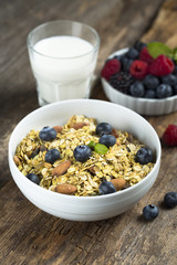 Homemade granola with fresh berries and mint, served with milk