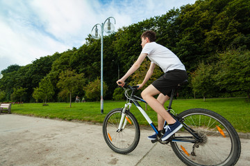 Fototapeta na wymiar Young man biking in city park