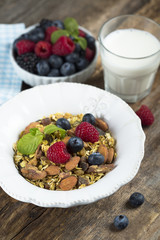 Homemade granola with fresh berries and mint, served with milk