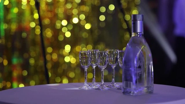 Bottle of liquor on the table, a bottle of vodka and wine glasses on a buffet table