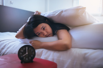 Young asian woman hates getting stressed waking up early,Female stretching her hand to ringing...