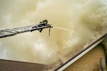 A firefighter puts out a burning building with height extension ladders