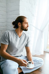 Man Drinking Coffee At Home In Morning.