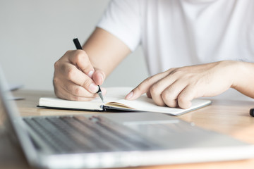 writing, knowledge and learning concept, hand of man recording information on notebook