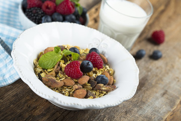 Homemade granola with fresh berries and mint, served with milk