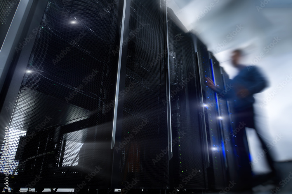 Poster shot of in large data center full of moving and working people. pronounced motion blur. computer eng