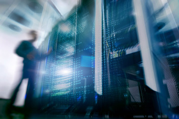 Shot of in Large Data Center Full of moving and working people. Pronounced Motion Blur. Computer Engineer Opening Server Rack Door In Data Center. 