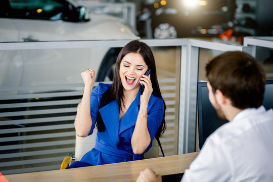 Happy excited customer female screaming with delight getting the aproval on bank loan buying a new car