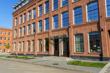 Fototapeta na wymiar Office building of red brick in the yard of the old factory