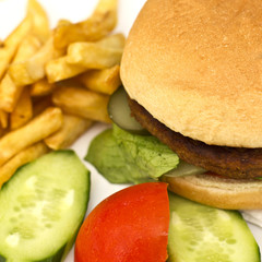 Hamburger with French fries, sliced cucumbers and tomatoes
