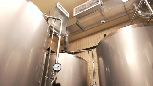 Close up tanks in brewery warehouse. Metal brewery vessels, up view.