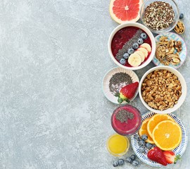 Breakfast food table. Healthy breakfast or brunch set, meal variety with granola, smoothie ,fresh berries, fruits and various of topping. Overhead view, copy space