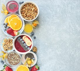 Breakfast food table. Healthy breakfast or brunch set, meal variety with granola, smoothie ,fresh berries, fruits and various of topping. Overhead view, copy space