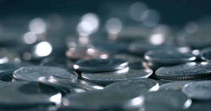 pan shot of close up money coin stacking on  the floor in dark light , business and financial for money saving or the investment background concept  , extremely close up and shallow DOF