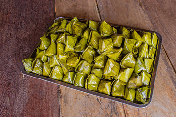 Stuffed Dough Pyramid Dessert put on tray on brown wooden background for Chinese New Year festival. Kanom Tian