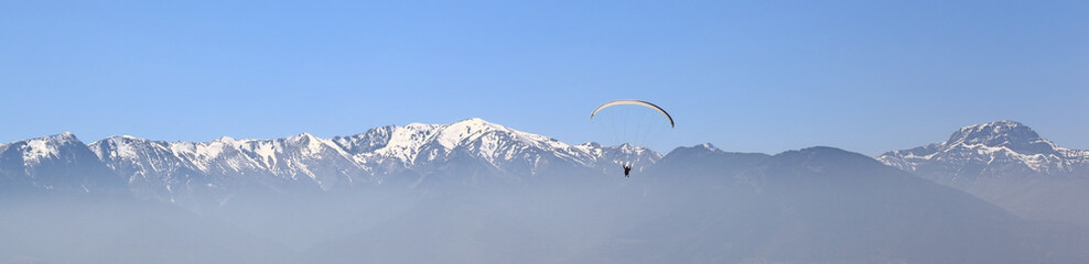 Fototapeta na wymiar Banner: Paragliding against mountain tops